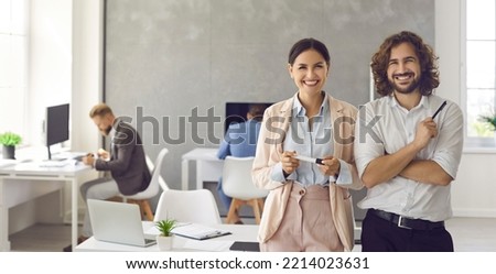 Happy smiling young business people in modern office workplace. Banner background with portrait of two satisfied successful colleagues, team leaders, teammates, business partners and friends at work Royalty-Free Stock Photo #2214023631