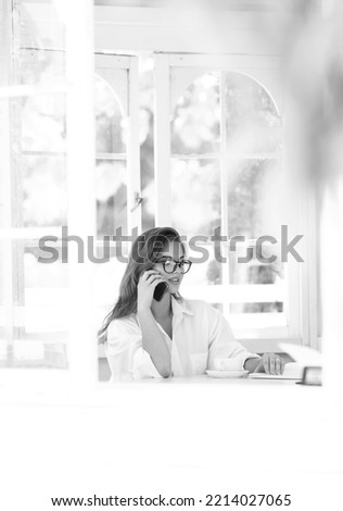                     Portrait of a beautiful business lady. Talking on the phone and smiling.Black and white photo           