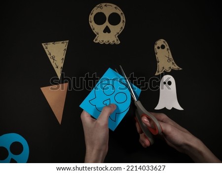 a training picture of how to make figurines for the Halloween holiday. on a black background, blank triangle skulls and casts are cut out of cardboard from above, and from below, ready-made figurines 