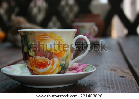 Tea cup on a wooden table located in the yard.