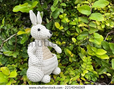 Kangaroo Knitting Doll Made by the hands of those who love to knit. resting on green and yellow trees with its baby in the ventral ventricle.