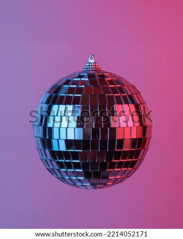 Disco ball floating in the air, isolated in blue-red neon gradient light. Levitating objects. Party concept. Minimal concept Royalty-Free Stock Photo #2214052171