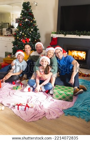 Vertical picture of caucasian family spending time together and siting next the christmas tree. Christmas, family time and celebration concept.