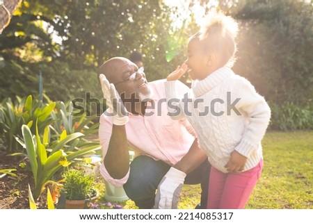 African american father and daughter spending time together in the garden and gardening. Family time, garden, gardening.