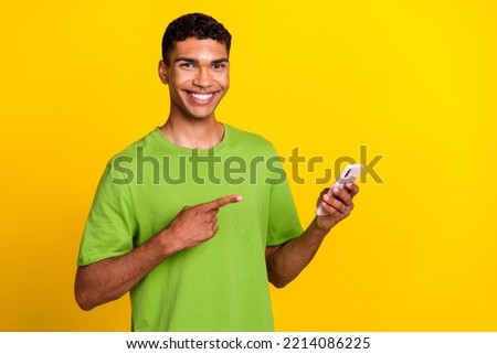 Photo of young handsome student successful freelancer blogger hold phone showing okey sign smile nice ad empty space isolated on yellow color background