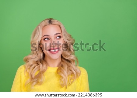 Photo of impressed young blond lady look empty space wear yellow pullover isolated on green color background