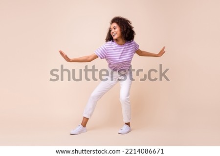 Full length photo of funny pretty lady wear violet t-shirt riding surf board isolated beige color background Royalty-Free Stock Photo #2214086671