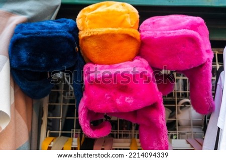 bright colored fur hats with earflaps on the counter of street vendor