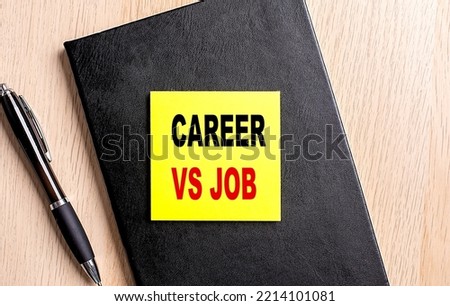 CAREER VS JOB text on sticky on black notebook with pen
