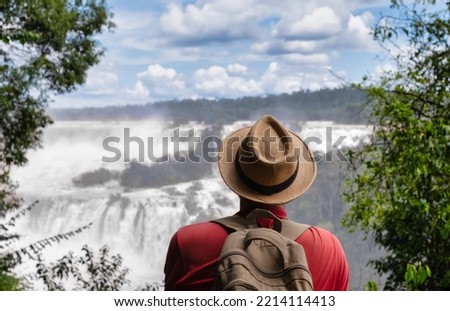 Iguazu Falls at Brazil and Argentina border - Traveling man visiting Iguassu  waterfalls - Wanderlust concept. Royalty-Free Stock Photo #2214114413