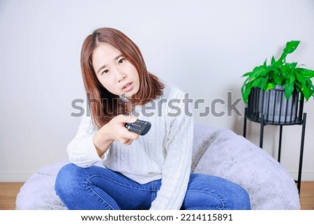 A woman who operates a TV remote control (winter clothes)
