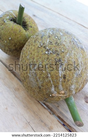 two breadfruit on a wooden table portrait