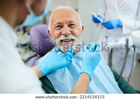 Happy mature man during teeth check-up at dental clinic. Royalty-Free Stock Photo #2214134153