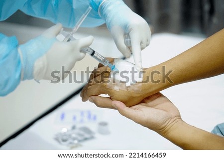 Doctor injects an injection into the hand of a patient with COVID-19