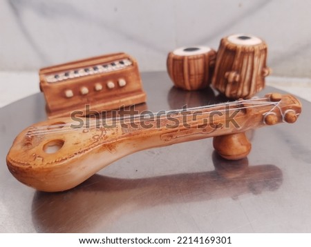 Small miniature musical instruments like tabla, harmonium, and sitar 