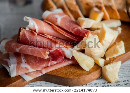 Wooden board with cheese and ham. Board with jamon and cheese. Aperitif on the board. Jamon with bruschetta and parmesan.Delicious appetizer for wine.Italian appetizer. Jamon and salami with cheese. Royalty-Free Stock Photo #2214194893