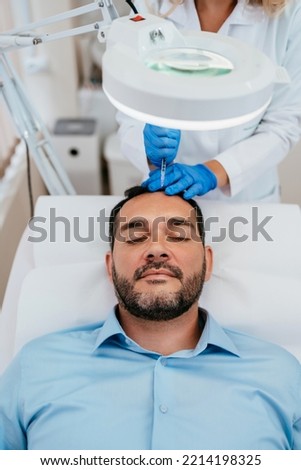 Handsome middle age man receiving advanced Platelet Rich Plasma PRP treatment against hair loss. Modern aesthetics treatments for males. Healthcare and beauty concept. Royalty-Free Stock Photo #2214198325