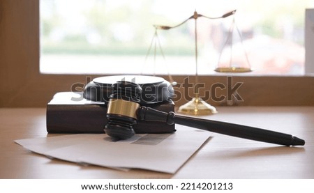 Lawyer or judge's hammer in the court. Auction's hammer and judgement golden scale are on wood table. Law subject. Judgement subject to judge people.