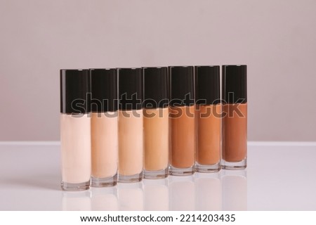 range of shades of liquid foundation in bottles isolated on background sale of beauty products concept