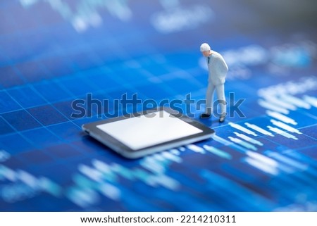 Miniature people: Businessman look ipad with copy space for text using as background saving, investment, money, financial, business analytics concept.