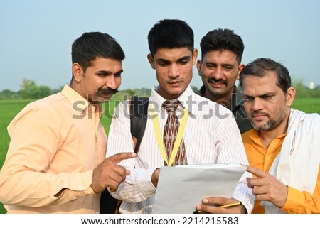 Indian farmers and agronomist standing at field