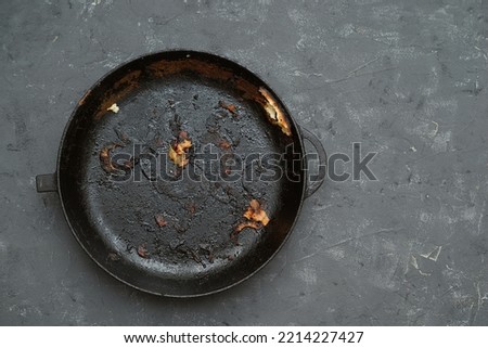 old cast iron pan with burnt food. carcinogen Royalty-Free Stock Photo #2214227427