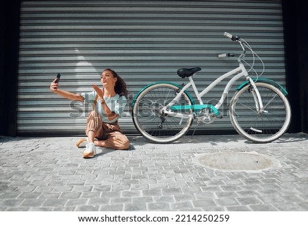Bicycle, street and woman taking a selfie in a city blowing a kiss in photo or pictures in summer outdoors. Freedom, bike and young girl creating phone content for social media followers in holidays
