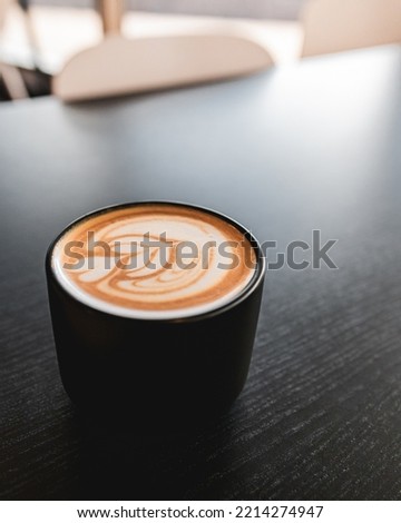 Espresso coffe cup picture in a black table background with heart art mixed with milk. Barista coffe art with latte milk on top. Delicious espresso coffe wallpaper. Peaceful environment coffeshop.