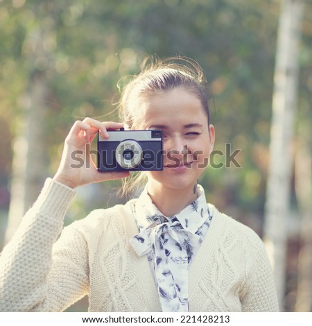 Hipster girl shooting on film camera outdoor