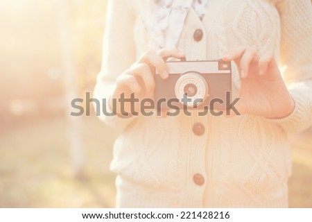 Hipster girl holding a film camera outdoor