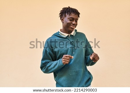 African american man smiling confident dancing over isolated yellow background