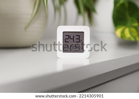 Digital hygrometer with thermometer on white table Royalty-Free Stock Photo #2214305901