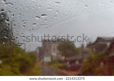 water drops on car windshield against building background.