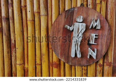 Men’s restroom sign on bamboo wooden wall