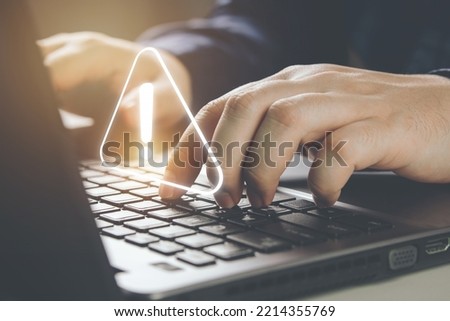 Businessman using laptop computer with alerts, warning triangles showing system errors. Concept of system maintenance, security, virus protection and hacking prevention accessing important information Royalty-Free Stock Photo #2214355769