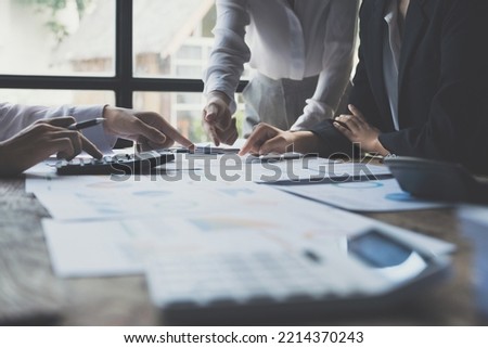 Asian Businessman working to analyze technical price graph and indicator with business team