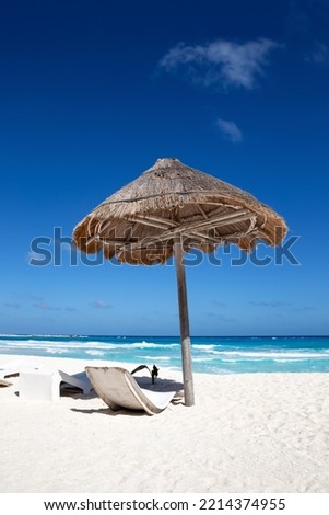 Sun umbrella ans sunbed on white sandy beach with turquoise ocean water. Caribbean sea travel destination. Bounty and pristine nature for vacation. Nobody Royalty-Free Stock Photo #2214374955