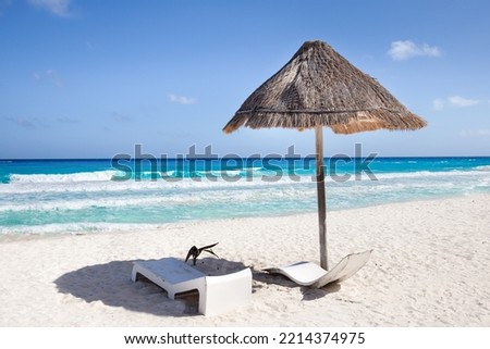 Sun umbrella ans sunbed on white sandy beach with turquoise ocean water. Caribbean sea travel destination. Bounty and pristine nature for vacation. Nobody Royalty-Free Stock Photo #2214374975