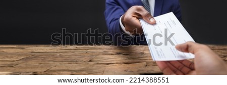 Giving Payroll Cheque. Hand Holding Compensation Check Royalty-Free Stock Photo #2214388551