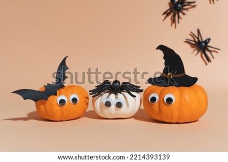 Decoration for Halloween party - cute pumpkin heads with eyes and good faces. Witch hat, flying bat and spiders. Not scary Halloween decoration. Art activity for kids, diy master class