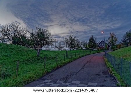 Beautiful scenic morning sky with rural road and apple trees in the background at City of Zürich on a blue cloudy autumn day. Photo taken October 9th, 2022, Zurich, Switzerland.