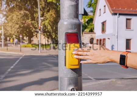 Aware passenger presses the traffic light control button to safely cross the street. Accident reduction rules Royalty-Free Stock Photo #2214399957