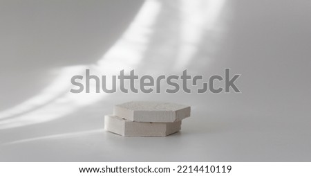 Empty gypsum stones platform podium on white light and shadow interior horizontal long background. Minimal empty display product presentation scene.