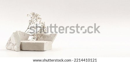 Empty stack of stones platform podium, flower twig  on beige background. Minimal empty display product presentation scene.