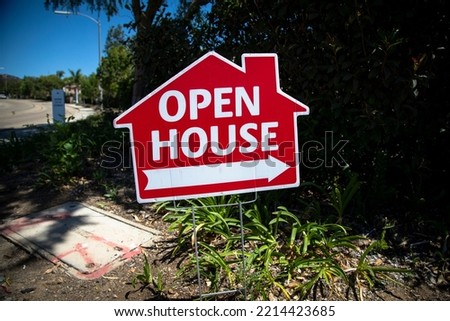 Red open house sign in the shape of a house