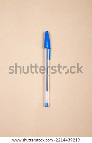 Blue Ballpoint pen with pen lid on top on a beige background Royalty-Free Stock Photo #2214439219