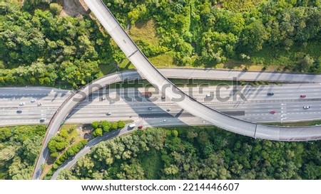 Aerial view directly above a six lane highway. Top view of asphalt road passes through the field and forest. Aerial. Sedan cars driving by the highway. Top view from drone. aerial photo autobahn road Royalty-Free Stock Photo #2214446607