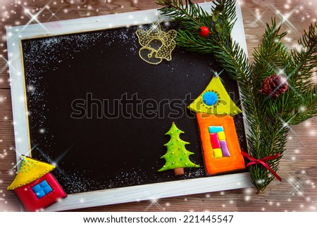 Blackboard decorated with colorful cookies and fir tree branch 