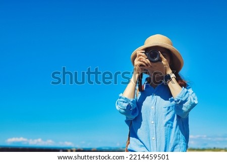 Woman taking a photo and blue sky