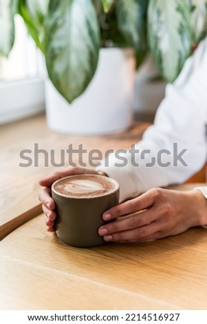 Woman ready to drink hot chocolate. Female hand holding cup with warm hot drink